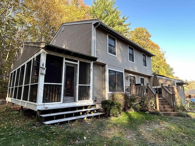 back of house featuring a sunroom, a yard, and a deck