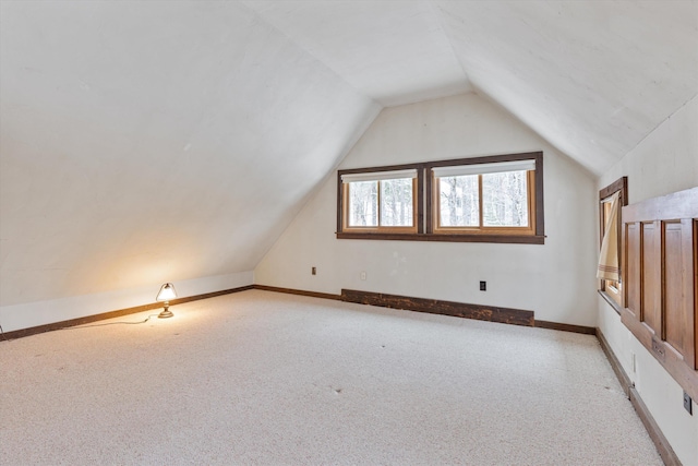 bonus room featuring lofted ceiling and light carpet