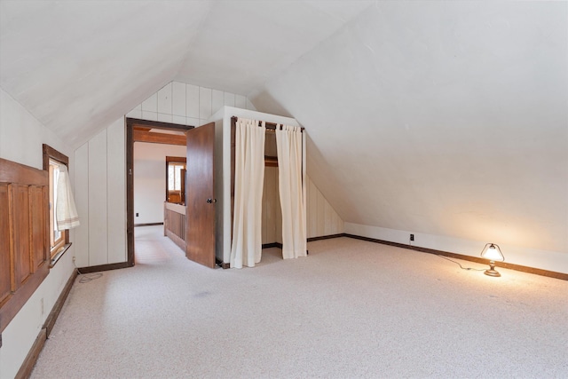 additional living space with vaulted ceiling and light colored carpet