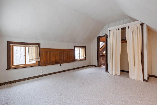 bonus room with vaulted ceiling and light carpet