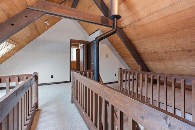 hall featuring vaulted ceiling with beams, light carpet, and wooden ceiling