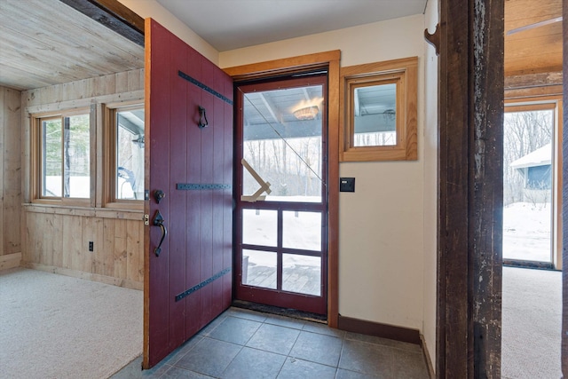 carpeted entryway featuring wooden walls