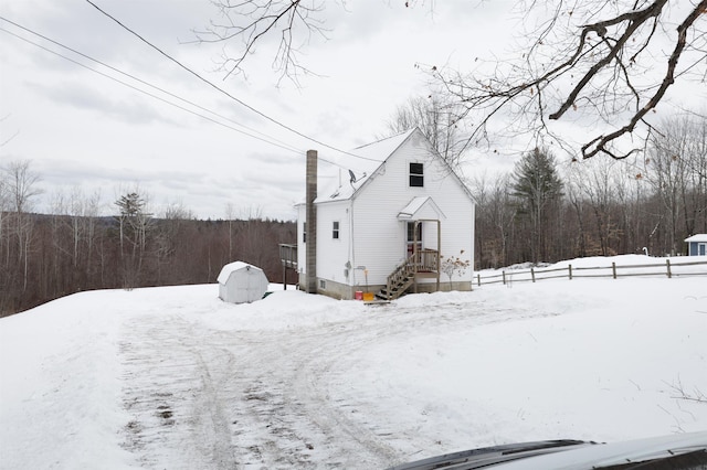 view of snow covered exterior featuring a storage shed