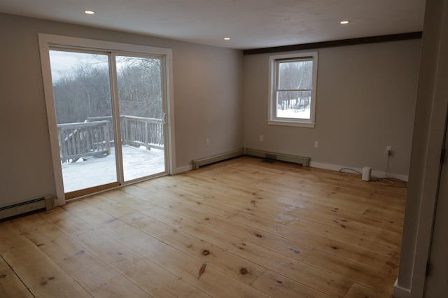 spare room featuring a baseboard radiator and light hardwood / wood-style flooring