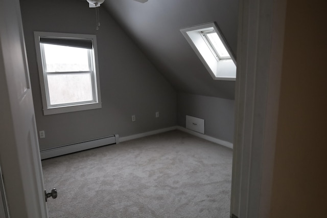 additional living space featuring lofted ceiling, light colored carpet, and baseboard heating