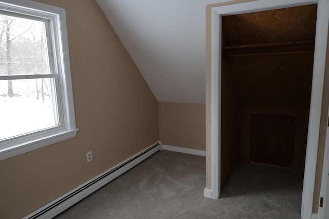 additional living space with a baseboard heating unit, vaulted ceiling, and carpet flooring