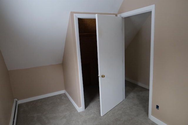 additional living space featuring vaulted ceiling, light carpet, and baseboard heating