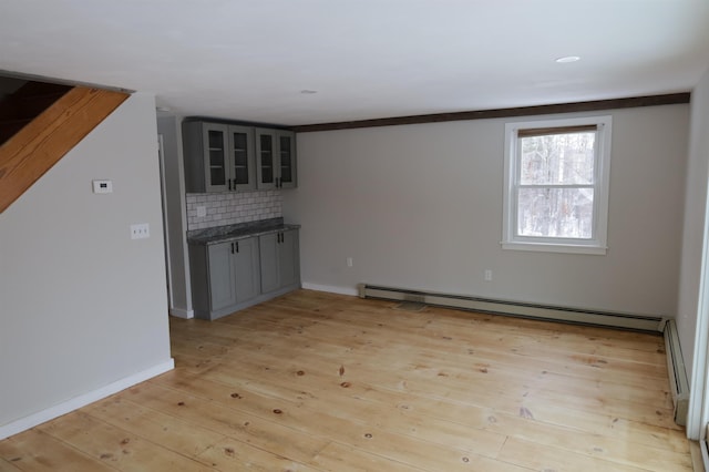 unfurnished living room with a baseboard radiator and light hardwood / wood-style floors