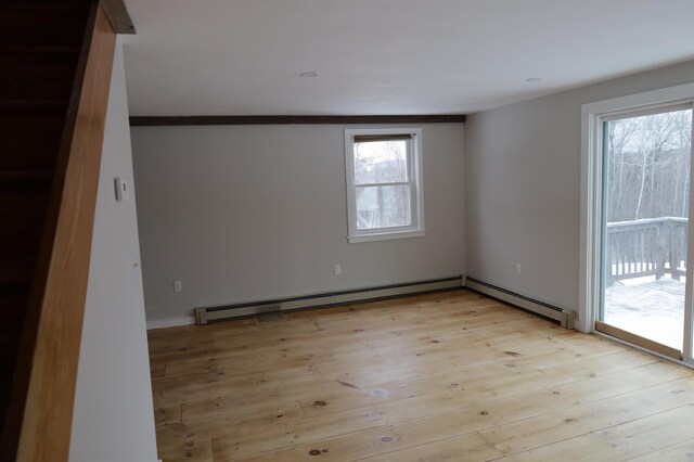 empty room with a baseboard heating unit and light wood-type flooring