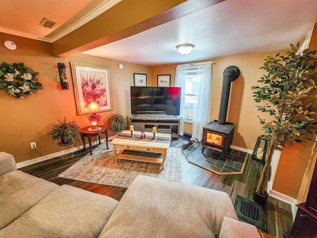 living room featuring hardwood / wood-style flooring, ornamental molding, and a wood stove