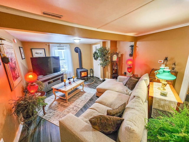 living room featuring crown molding, a wood stove, and hardwood / wood-style floors