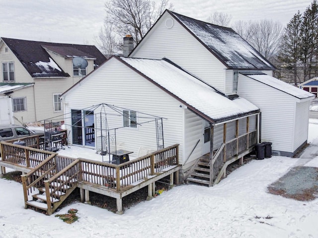 snow covered property with a deck