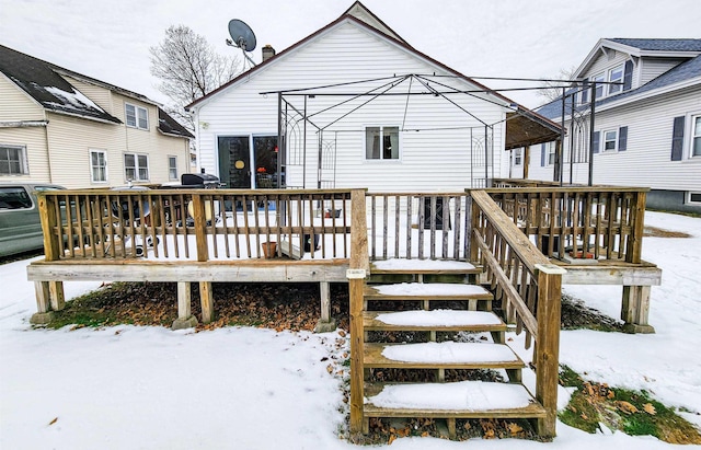 snow covered house featuring a deck