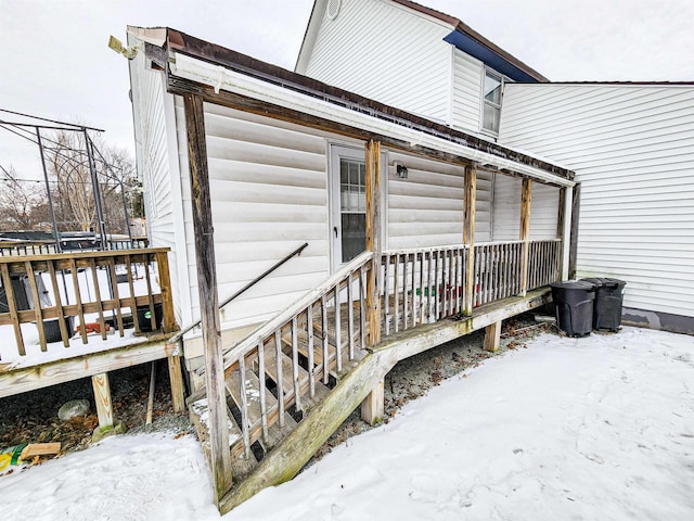 snow covered property entrance with a deck