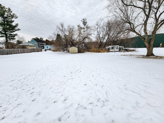 yard layered in snow with a storage shed