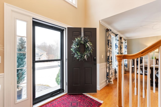 entryway with crown molding and light hardwood / wood-style flooring