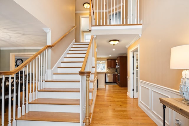 staircase featuring hardwood / wood-style flooring and ornamental molding