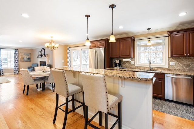 kitchen with pendant lighting, sink, a kitchen bar, and appliances with stainless steel finishes