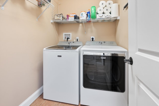 laundry area featuring separate washer and dryer and light tile patterned floors