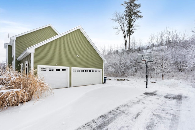 view of snowy exterior featuring a garage