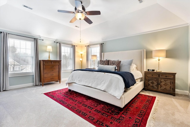 carpeted bedroom featuring ceiling fan, a raised ceiling, and vaulted ceiling