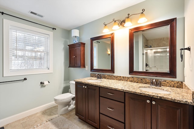 bathroom with vanity, toilet, and a shower with shower door