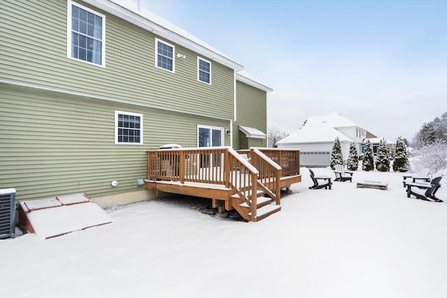 snow covered rear of property featuring a wooden deck and central air condition unit