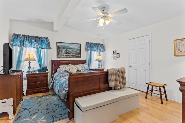 bedroom featuring ceiling fan, vaulted ceiling with beams, and light hardwood / wood-style floors