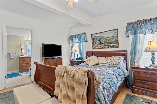 bedroom with ceiling fan, connected bathroom, light hardwood / wood-style floors, and lofted ceiling with beams