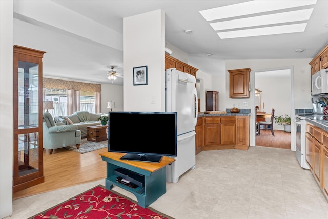 kitchen with ceiling fan, white appliances, and a skylight