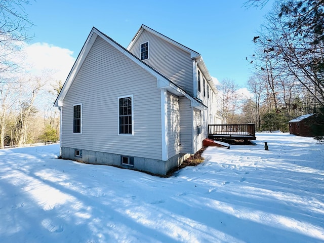 view of snow covered exterior with a deck