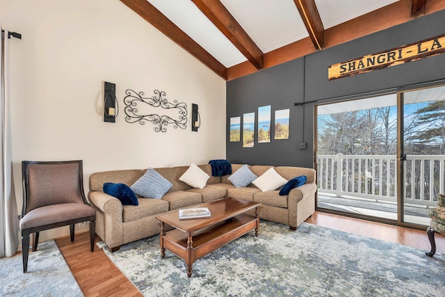 living room featuring hardwood / wood-style flooring, beam ceiling, and high vaulted ceiling