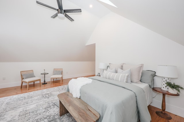 bedroom featuring ceiling fan, hardwood / wood-style flooring, and vaulted ceiling with skylight