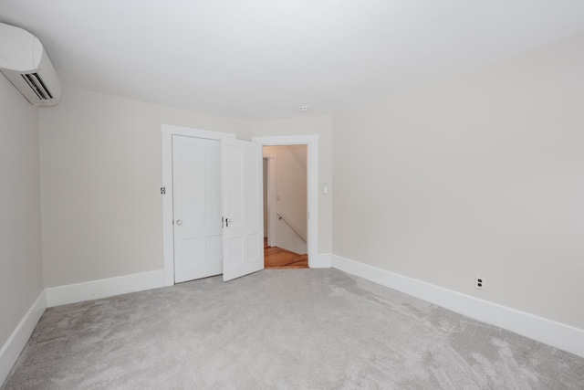 unfurnished bedroom featuring a closet, an AC wall unit, and carpet flooring