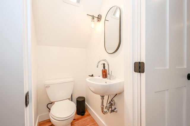 bathroom featuring vaulted ceiling, hardwood / wood-style floors, and toilet