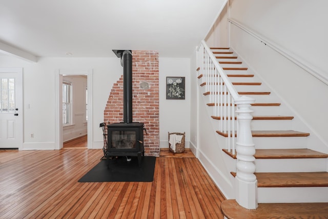 unfurnished living room featuring wood-type flooring and a wood stove