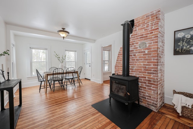 dining room with a wood stove and light hardwood / wood-style flooring