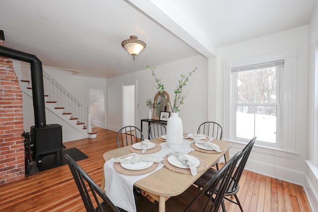 dining area with light hardwood / wood-style flooring and a wood stove