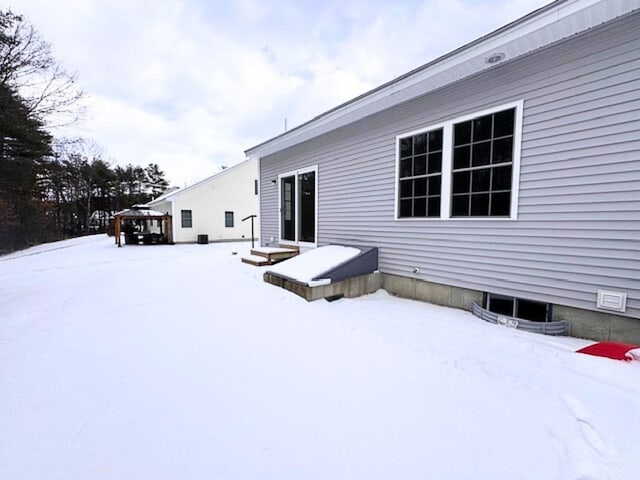 view of snow covered back of property