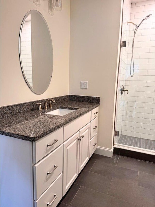 bathroom with vanity, a tile shower, and tile patterned floors