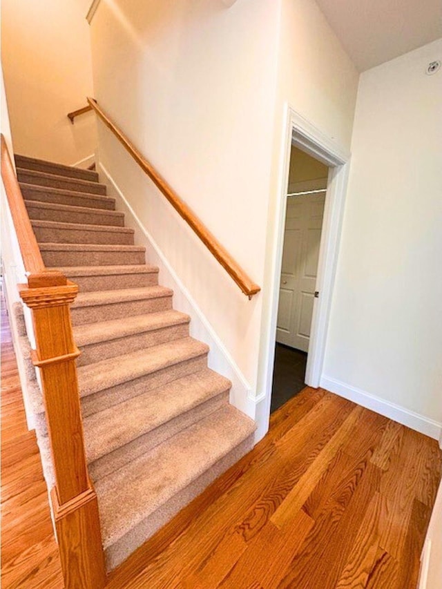 stairs featuring hardwood / wood-style floors