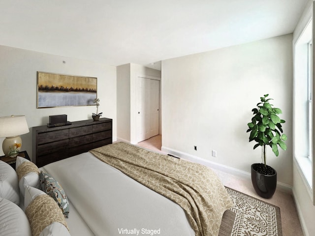 bedroom featuring light carpet and a closet