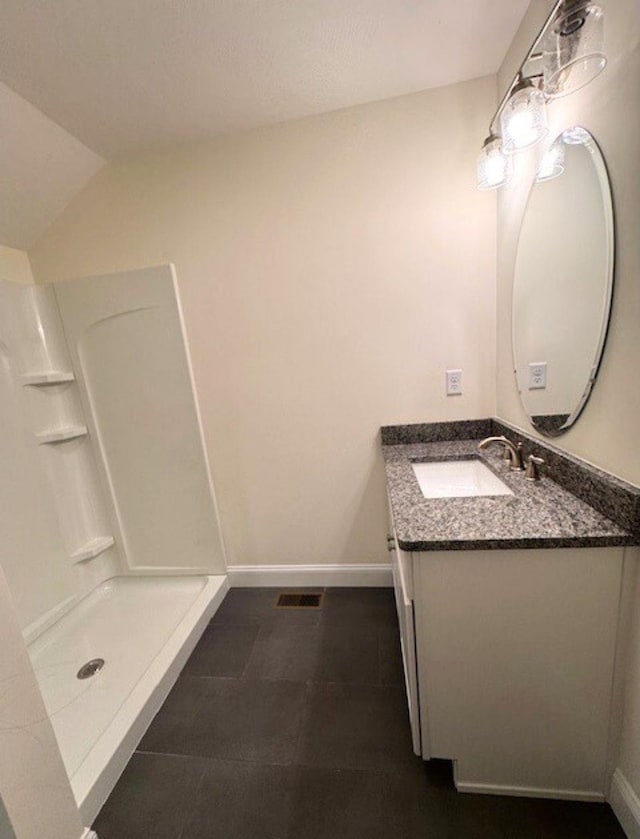 bathroom with lofted ceiling, vanity, tile patterned flooring, and a shower