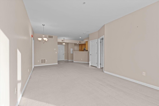 unfurnished living room with light colored carpet and a notable chandelier