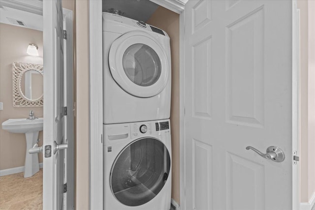 laundry room with stacked washing maching and dryer