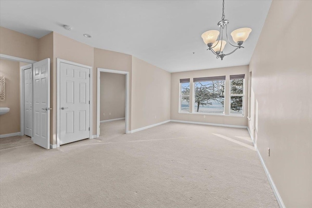 interior space featuring light colored carpet and a chandelier