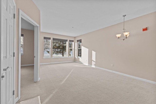 unfurnished living room with light colored carpet and a notable chandelier