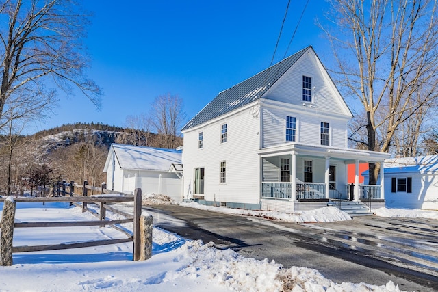 exterior space with an outbuilding, a porch, a garage, and a mountain view