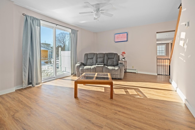 sitting room with ceiling fan, a baseboard radiator, and light hardwood / wood-style floors