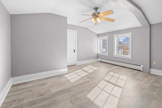 additional living space with a baseboard radiator, lofted ceiling, ceiling fan, and light hardwood / wood-style flooring